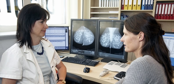 Zwei Personen besprechen radiologische Berichte.