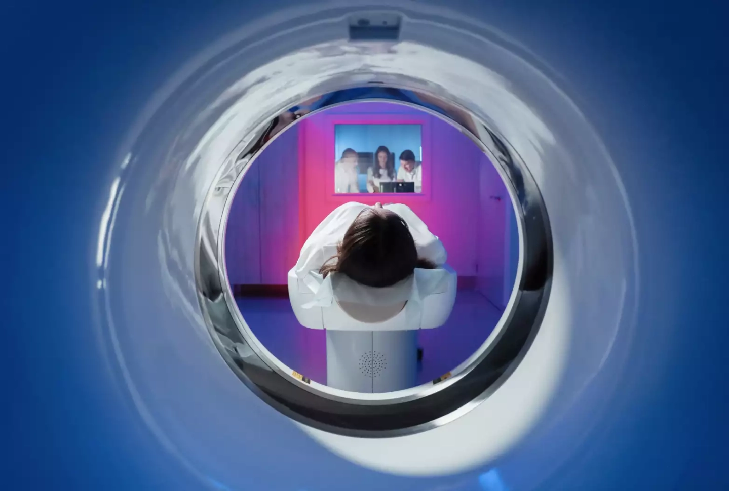 Patientin liegt auf einer Liege vor dem MRT