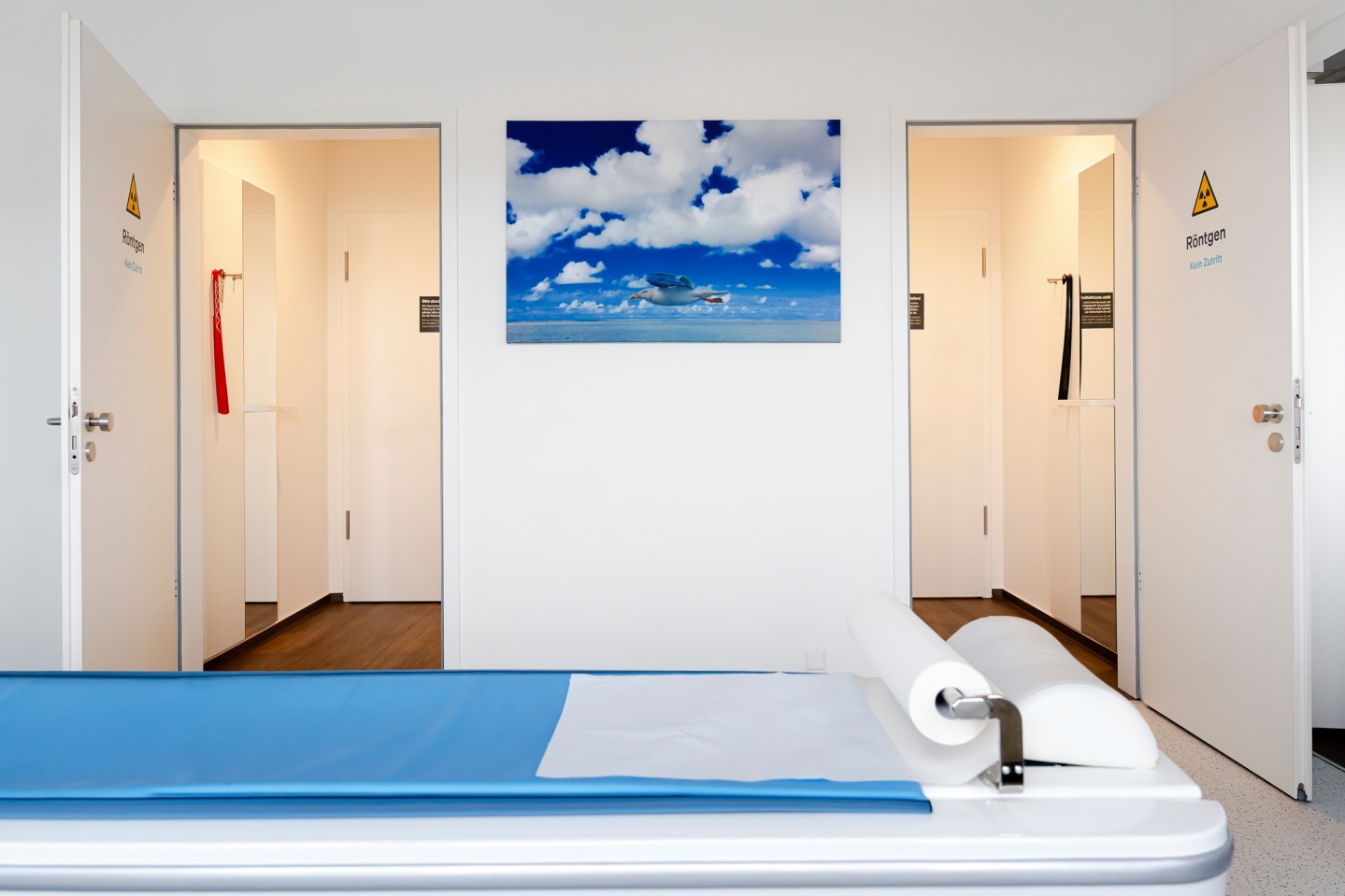 Untersuchungsraum in einer Praxis. Behandlungsliege und ein Landschaftsbild an der Wand.