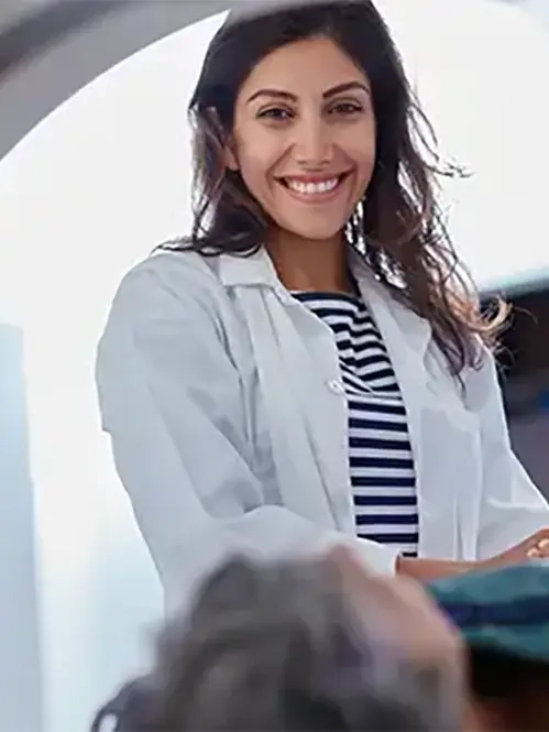 Ärztin beruhigt Patientin die in ein MRT geschoben wird